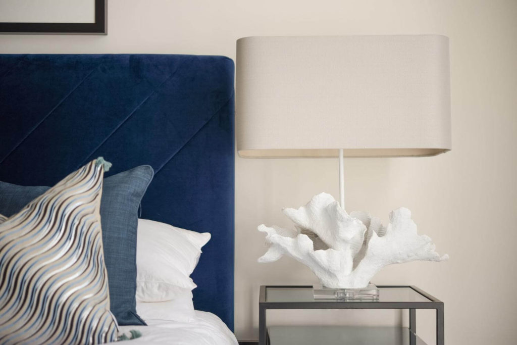 blue bed with white coral lamp