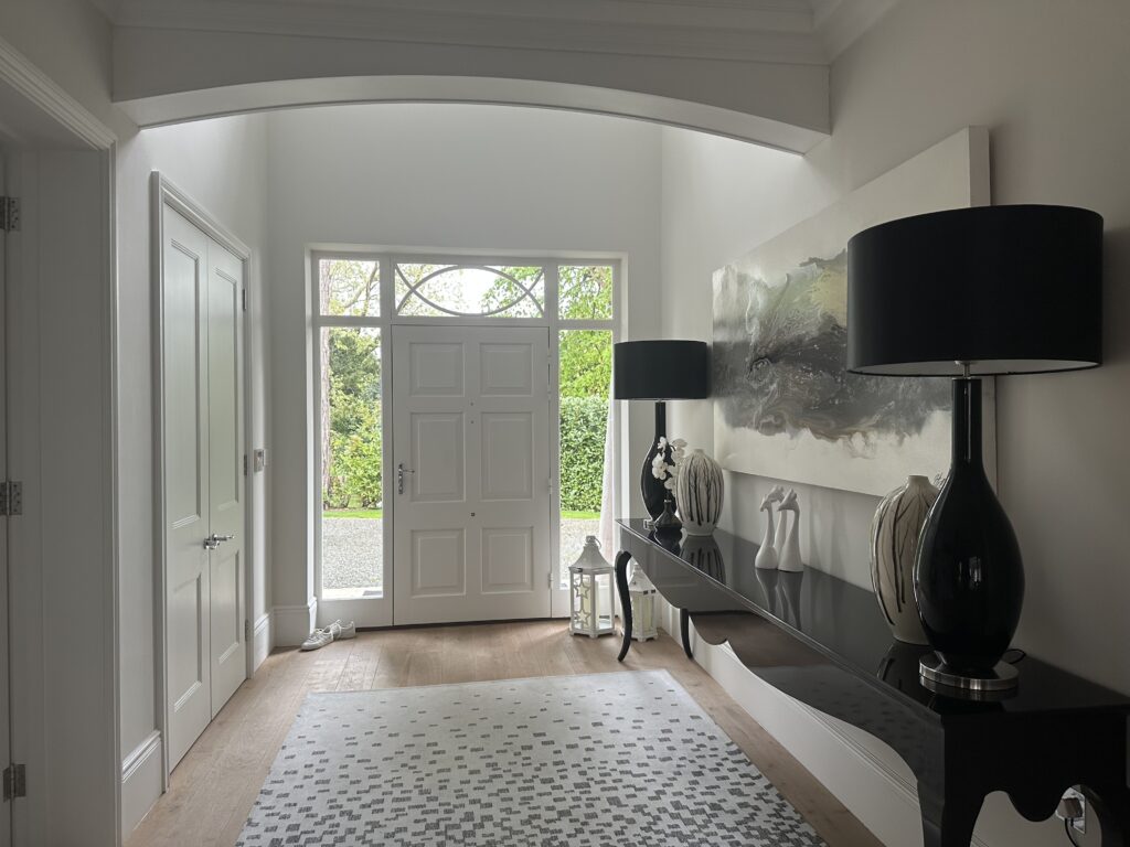 surrey family home hallway with black sideboard, black lamps and abstract artwork