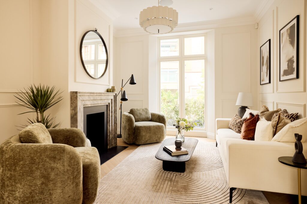 London family home staging living room scheme with cream sofa, decorative cushions and green velvet armchairs