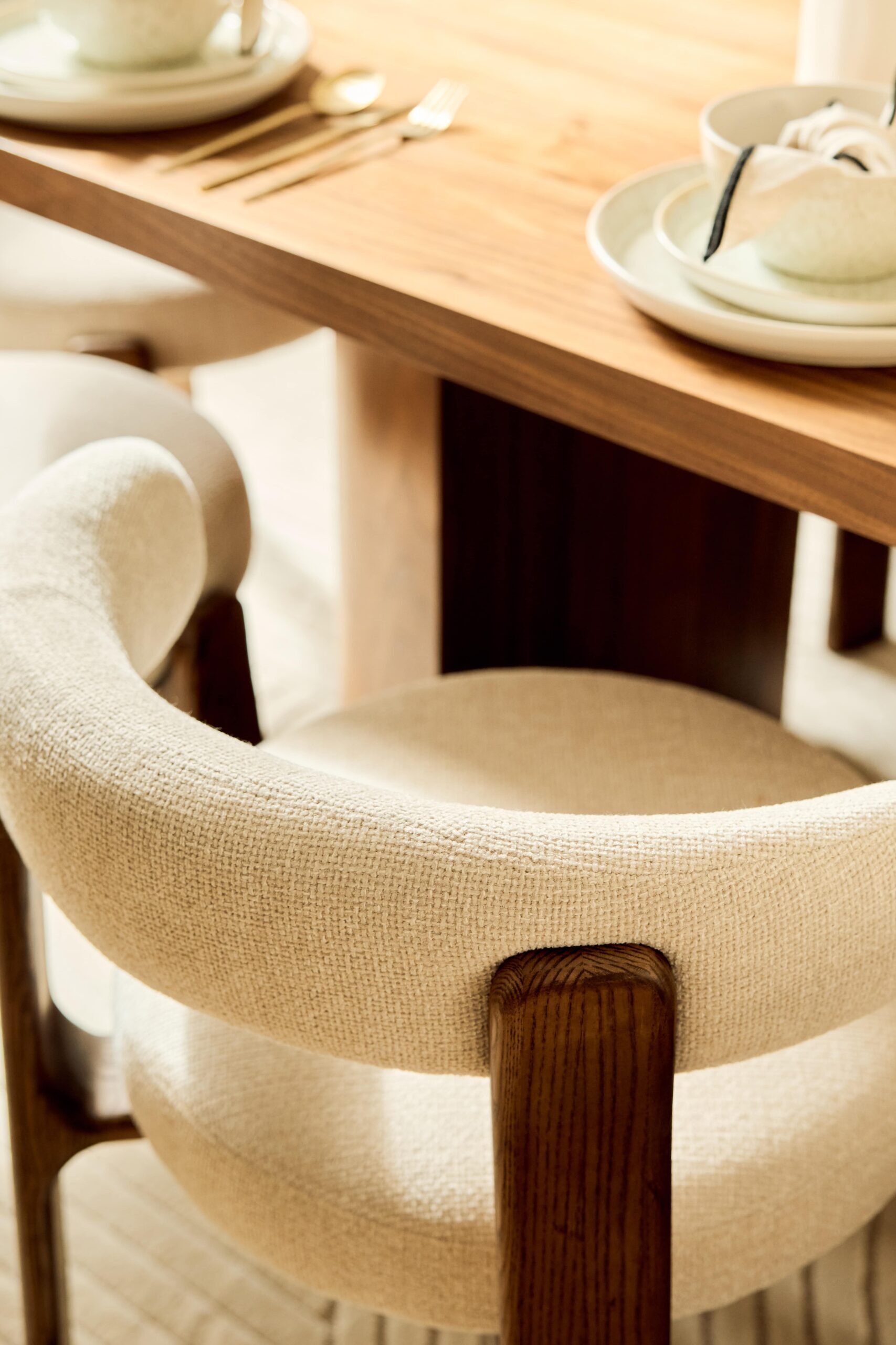close up of a cream linen chair with dark wood legs