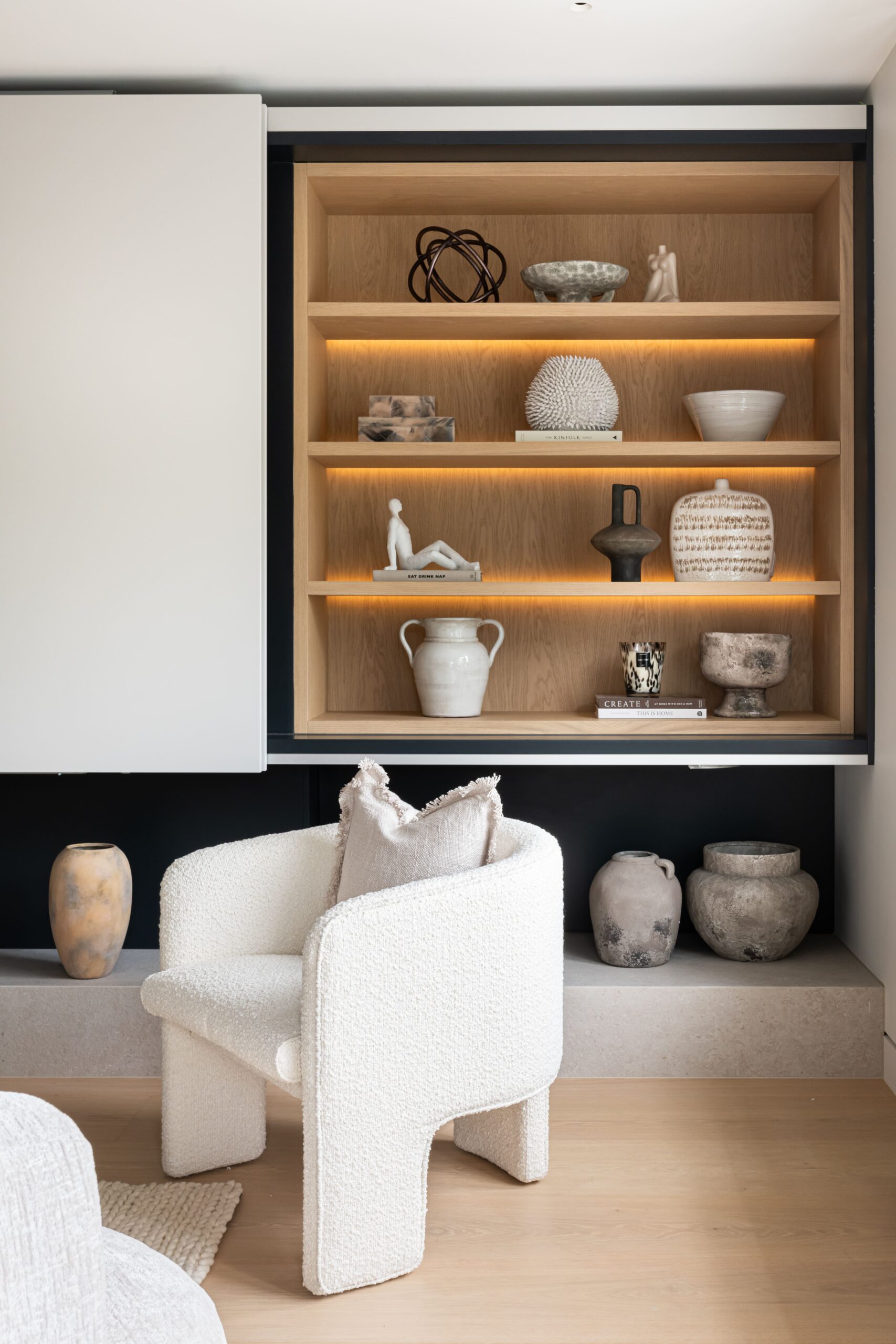 interior styled home with white boucle armchair and bespoke shelving with accessories