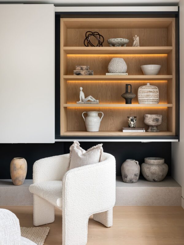 interior styled home with white boucle armchair and bespoke shelving with accessories